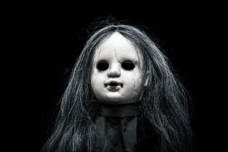 Scary doll face on dark backgroundの写真素材
