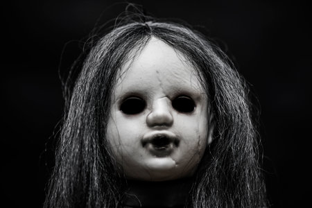 Scary doll face on dark backgroundの写真素材