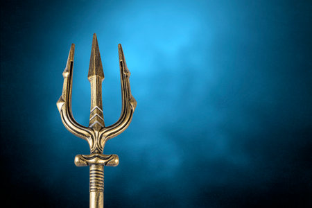 Golden trident over blue misty backgroundの写真素材