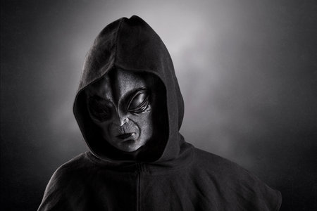 Mysterious humanoid alien at night over dark misty backgroundの写真素材