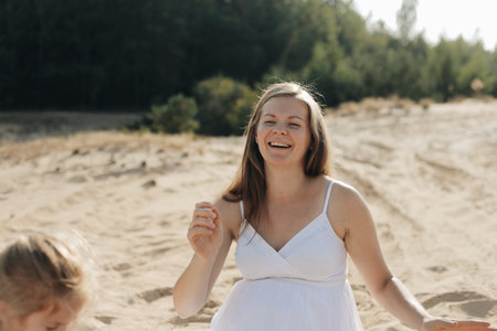 Beautiful Young Pregnant Women, wearing white long dress standing in desert sand dune sceneの写真素材