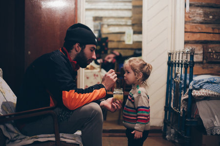 Young father feeding his little girl in old house, fatherhood.の写真素材