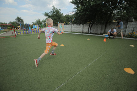 Belarus, Bobruisk - june 20, 2018: Little boy running around the playground. Artificial turfのeditorial素材