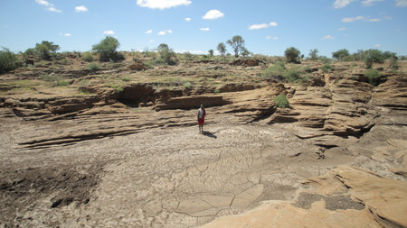 Beautiful landscape of a desert in Africa, Kenya. Man walking alone through the field in the distance.の写真素材