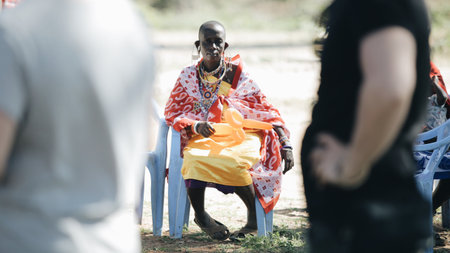 KENYA, KISUMU - MAY 20, 2017: African woman from local maasai tribe sitting on chair and hold balloon.のeditorial素材