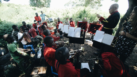 KENYA, KISUMU - MAY 20, 2017: Concert of an African band with a Caucasian dryer in the open air in sunny day.のeditorial素材