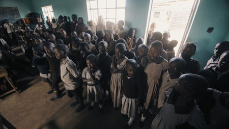 KENYA, KISUMU - MAY 20, 2017: Crowd of african children standing in big classroom. Boys and girls from poor african village.のeditorial素材