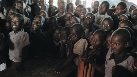 KENYA, KISUMU - MAY 20, 2017: Group of African children in uniform laugh and smile together at lesson at school in Africa.のeditorial素材