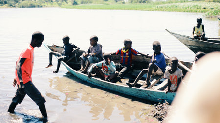 KENYA, KISUMU - MAY 20, 2017: Group of African children sitting in the boat and looking on the water of the sea.のeditorial素材