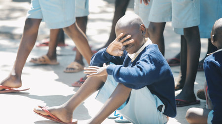 KENYA, KISUMU - MAY 20, 2017: Group of african children sitting on ground. Boys and girls in uniform spend time outside.のeditorial素材