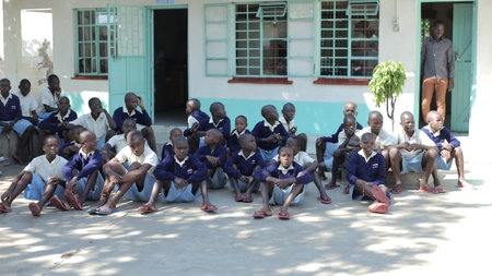 KENYA, KISUMU - MAY 20, 2017: Group of african children sitting on ground. Boys and girls in uniform spend time outside.のeditorial素材
