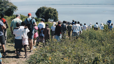 KENYA, KISUMU - MAY 20, 2017: Big group of African and Caucasian people are going together to the shore of the sea.のeditorial素材