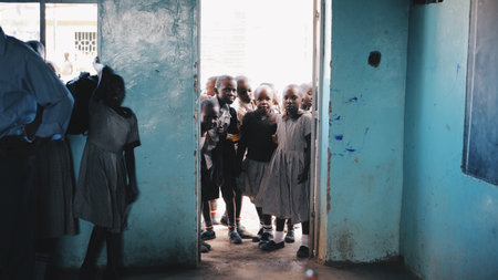 KENYA, KISUMU - MAY 20, 2017: Group of children in uniform comes into class and prepares for lesson at school in Africa.のeditorial素材
