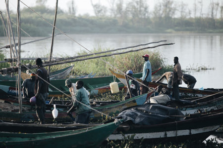 KENYA, KISUMU - MAY 20, 2017: View of the port by the river. African fishermen going to work in morning, preparing boat.のeditorial素材