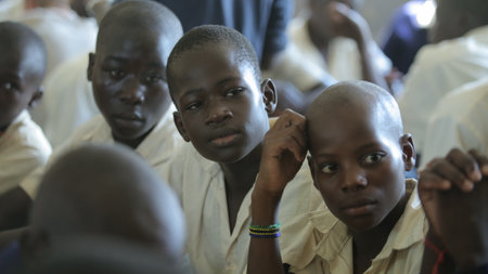 KENYA, KISUMU - MAY 23, 2017: Close-up view of three african boys in uniform sitting in classroom in schoolのeditorial素材