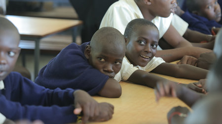 KENYA, KISUMU - MAY 23, 2017: Close-up view of three african boys in uniform sitting in classroom in schoolのeditorial素材