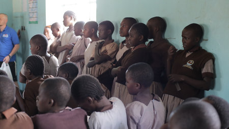 KENYA, KISUMU - MAY 23, 2017: Group of African guys stands near the wall in the school and looks straight. Boys are smiling.のeditorial素材