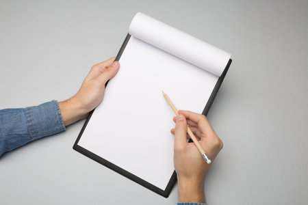 Hands holding clipboard and write / Mock-up.の写真素材