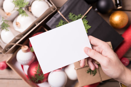 Christmas / New Year set with hand holding blank white flyer and dof backgroundの写真素材