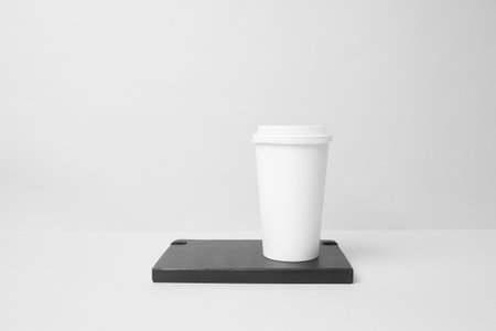 Blank paper cup on the top of the moleskineの写真素材