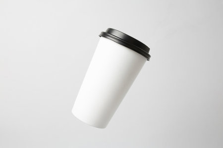 Blank white paper cup with a black cap in the airの写真素材
