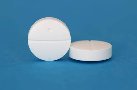 A close up of two white tablets on a lue background
