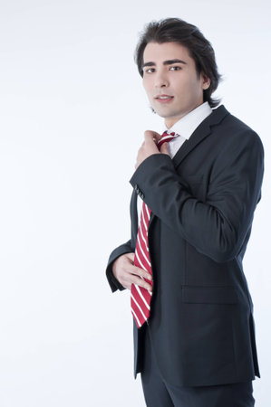 Confident young business man arranging his tieの写真素材