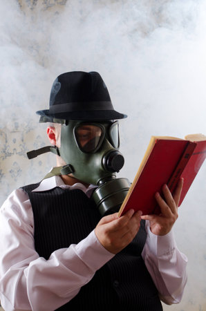 Businessman with a gas mask reading a book