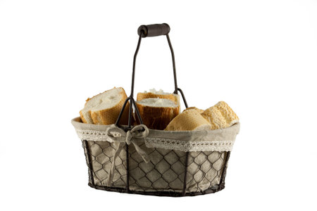 Fresh bread rolls in wire basket isolated on white background