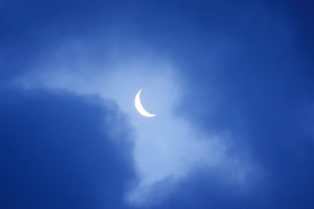 Crescent shaped moon against blue skyの写真素材
