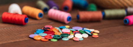 Items for sewing buttons and threads. Multi-colored buttons on the table.