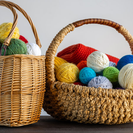 Multi-colored yarn in a basket on the table. Knitting concept. Hobby. Bright background with accessories for knitting.の写真素材