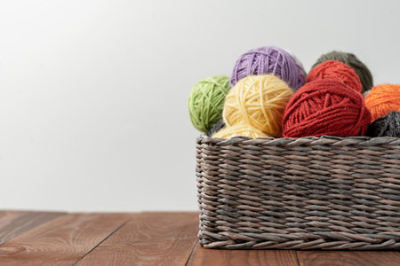 Yarn in a basket. Colorful balls of wool on wooden table. Variety of yarn balls, view from above.の写真素材