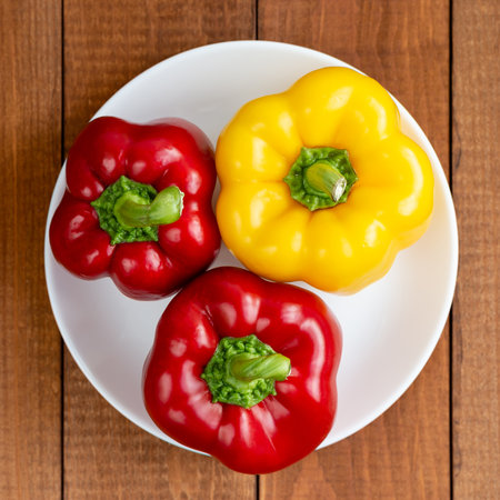 Ripe bell pepper on a white plate. A plate with vegetables on the table. Suitable for vegetarians. Diet food.の写真素材