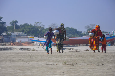 Dhaka, Bangladesh, 11 March 2018: A view of some women and children is going back home after taking water from famous river in Bangladesh name Padma. This picture was taken in the noon.のeditorial素材