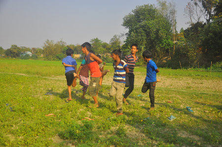 Dhaka, Bangladesh, 17 February 2018: An image of unidentified boys playing in the open field of a rural area near Dhaka, Bangladesh.のeditorial素材