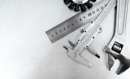 Metal style. Ð¡alliper and other metal tools on the scratched metal background.の写真素材