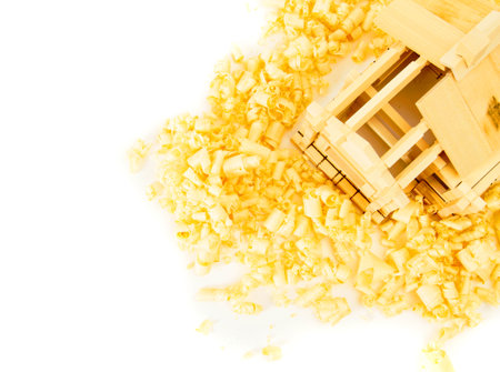 Woodworking. House construction. Joiners works. The wooden house and shaving on white background.の写真素材