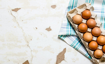 The cassette with eggs on the fabric . On a rustic background. Free space for text . Top viewの写真素材