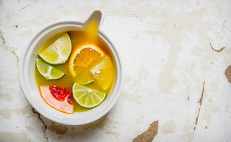 The juice from citrus fruits - grapefruit, orange, tangerine, lemon, lime in a cup. On rustic background. Free space for text . Top viewの写真素材