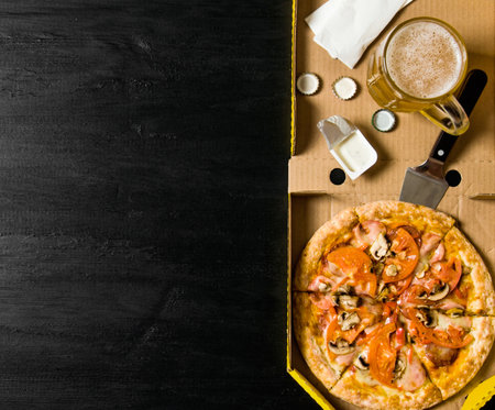 The concept of pizza with beer. Pepperoni pizza with beer on a wooden table. Top viewの写真素材