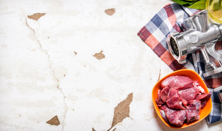 Raw meat with a hand grinder on the fabric. On rustic background. Free space for text . Top viewの写真素材