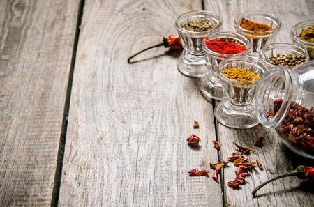 Different spices in glasses. On a wooden table. Free space for text .の写真素材
