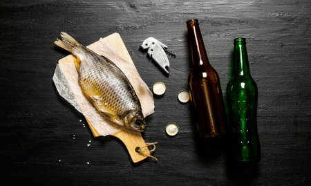Dried fish and beer bottles on the black board. Top view