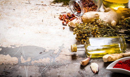 A set of dried spices and herbs with olive oil. On rustic background. Free space for text .の写真素材