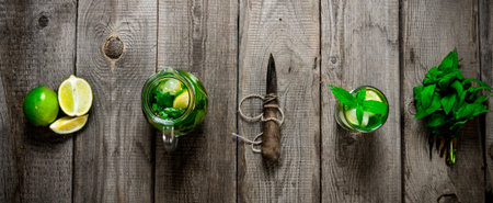 Mojito cocktail . The ingredients for the cocktail - mint leaves, limes, rum and a knife for citrus fruits on the wooden table. Top viewの写真素材