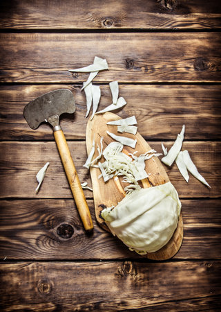 hopped cabbage with an old hatchet . On wooden background.の写真素材