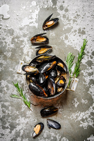 Fresh clams in a pot, and rosemary. On the stone table. Top viewの写真素材