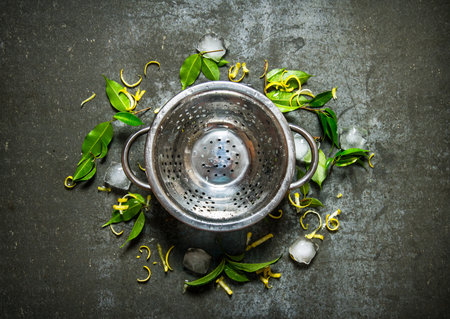 Empty the pot with leaves, ice and lemon zest around. On the stone table. Top view
