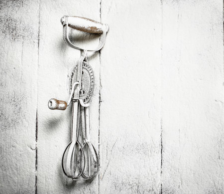 Baking background. Old tool for beating eggs and blending dough.の写真素材
